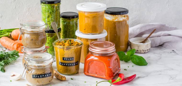 Unterschiedliche Gläser mit bunten Gewürzpasten Unterschiedliche Gläser mit bunten Gewürzpasten