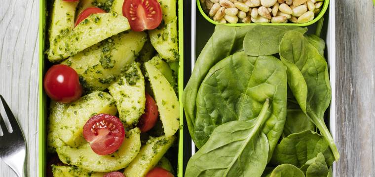 Kartoffelsalat mit Pesto, Tomaten, Spinat und Pinienkernen in Aufbewahrungsboxen