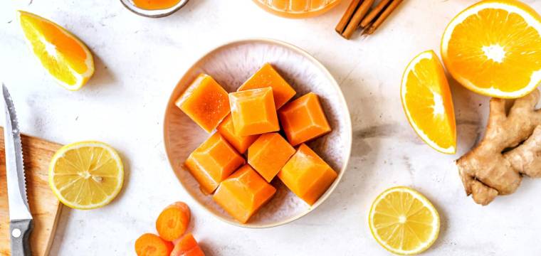 Orangen, Orangensaft, Zimtstangen und orange Eiswürfel Orangen, Orangensaft, Zimtstangen und orange Eiswürfel