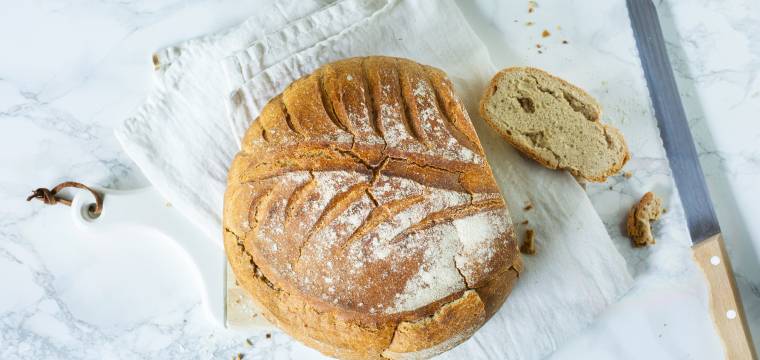 Brotlaib angeschnitten mit angelegtem Brotmesser Brotlaib angeschnitten mit angelegtem Brotmesser