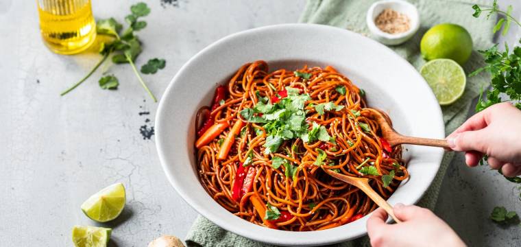 Spaghetti mit Gemüse, Kräutern und frischer Limette in großer Schüssel