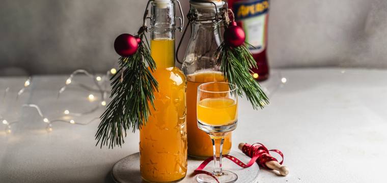 Zwei Flaschen mit orangefarbenem Likör, daneben ein Glas