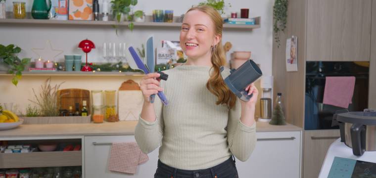 Junge Frau hält Monsieur Cuisine Zubehör in den Händen