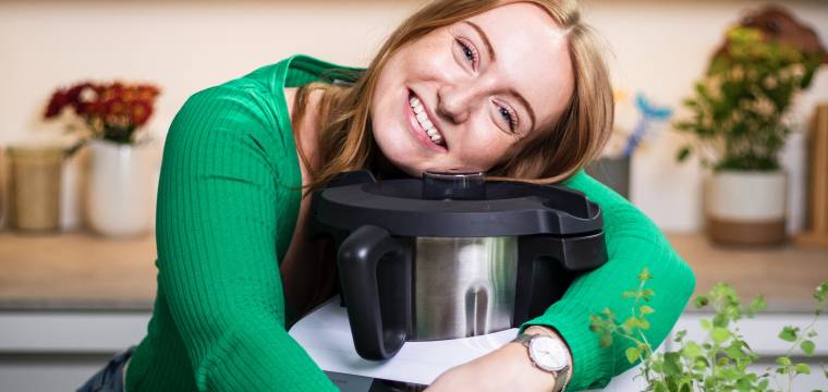 Eine Frau lächelt und umarmt den Monsieur Cuisine