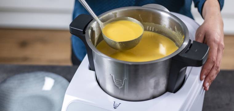 Jemand holt mit einer Kelle Suppe aus dem Monsieur Cuisine