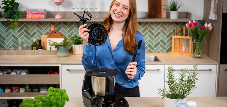 Junge Frau mit einem Monsieur Cuisine compact und Zubehör in der Hand