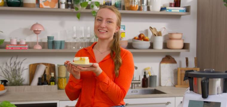 Junge Frau mit einem Stück Kuchen in einer Küche, neben dem Monsieur Cuisine Junge Frau mit einem Stück Kuchen in einer Küche, neben dem Monsieur Cuisine