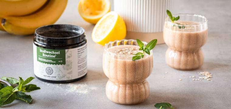 Zwei Gläser mit einem Smoothie, daneben Stoffwechsel Routine Produkt von Nature Love