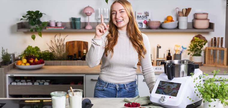 Junge Frau in einer Küche neben dem Monsieur Cuisine