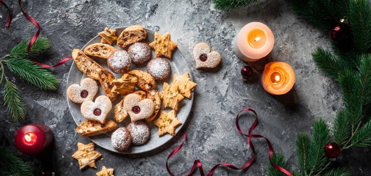 Teller mit Plätzchen, von oben fotografiert auf grauem Untergrund Teller mit Plätzchen, von oben fotografiert auf grauem Untergrund
