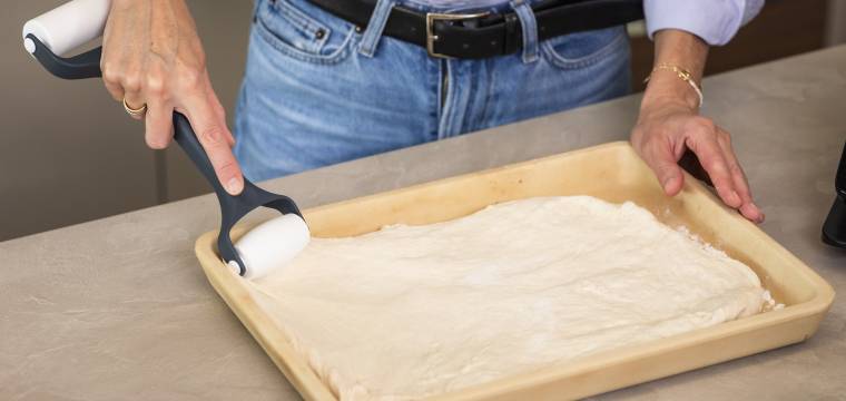 Hände rollen Teig aus mit RollPro Teigroller Hände rollen Teig aus mit RollPro Teigroller