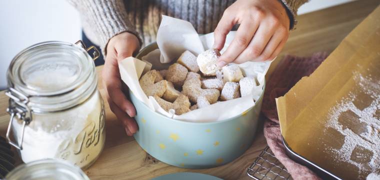 Hände halten eine Dose mit Plätzchen Hände halten eine Dose mit Plätzchen