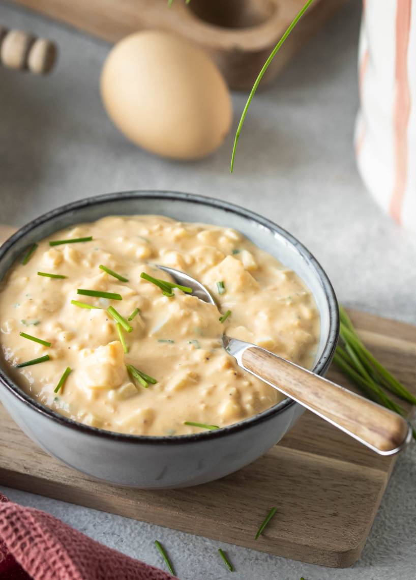 Eiersalat in einer Schale und auf Broten