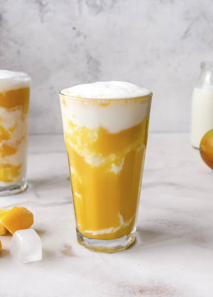 Mangoüpürree mit weißer Creme geschichtet im Glas