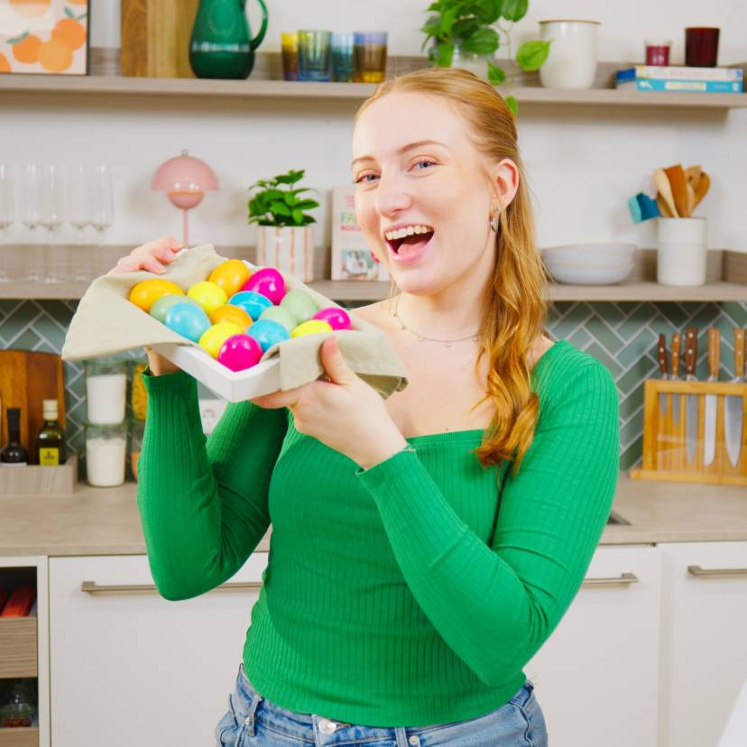 Isy hält einen Korb mit bunten Ostereiern