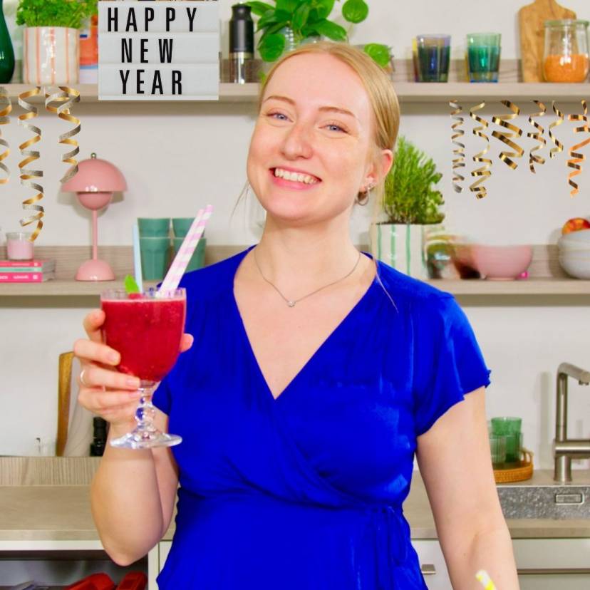 Eine Frau mit einem Cocktail in einer Küche