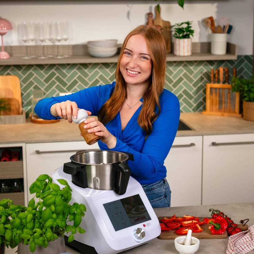 Junge Frau kocht mit dem Monsieur Cuisine