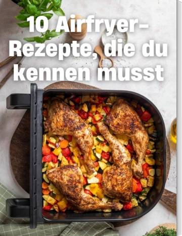 Airfryer-Schublade mit Gemüse und Hähnchen-Keulen darin