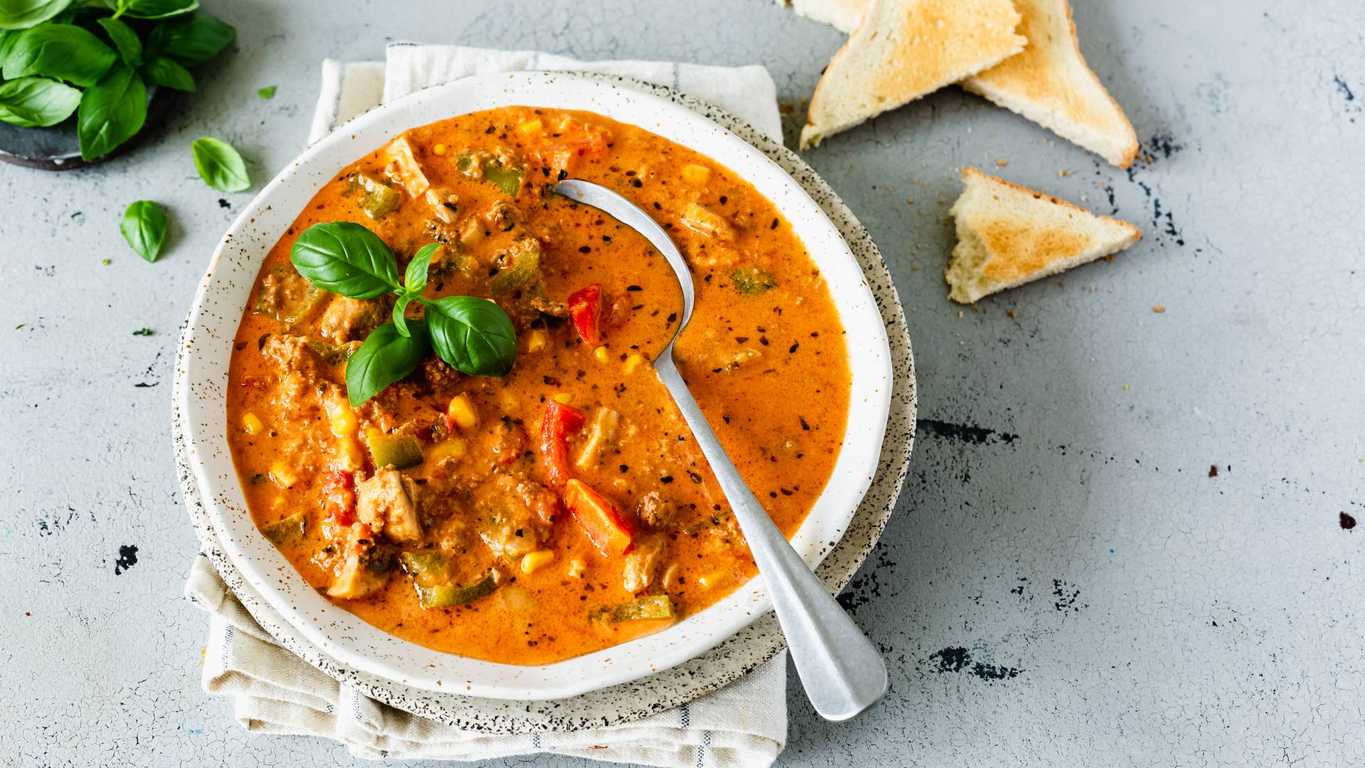 Pizzasuppe in einem tiefen Teller mit Löffel