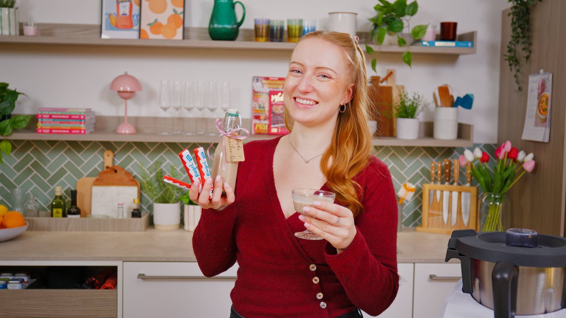 Isy hält den Likör in der Hand